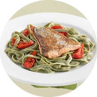 Weißes Teller mit einer Portion Lachsforelle mit Tagliatelle Verde und Zitronensauce Weißes Teller mit einer Portion Lachsforelle mit Tagliatelle Verde und Zitronensauce