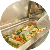 Ein Koch kocht Gemüse in einem großen Lavur